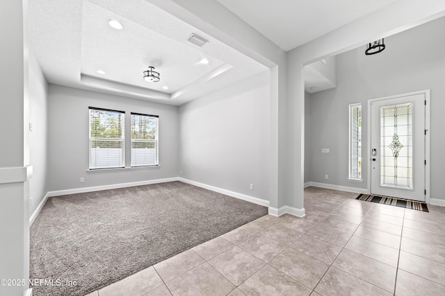 185 Calumet Dr, Saint Johns, FL 32259 - tiled entryway featuring a textured ceiling, visible vents, baseboards, a raised ceiling, and carpet floors