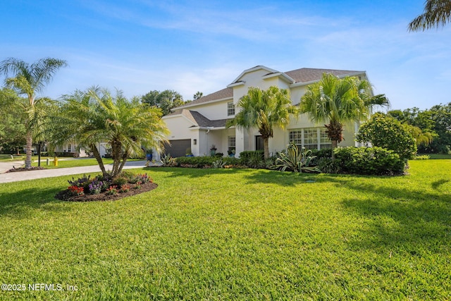 view of front of property featuring a garage, stucco siding, and a front lawn