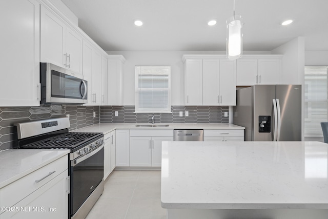 102 Fairlake Cir, Saint Augustine, FL 32092 - kitchen featuring light tile patterned floors, a sink, appliances with stainless steel finishes, white cabinetry, and backsplash