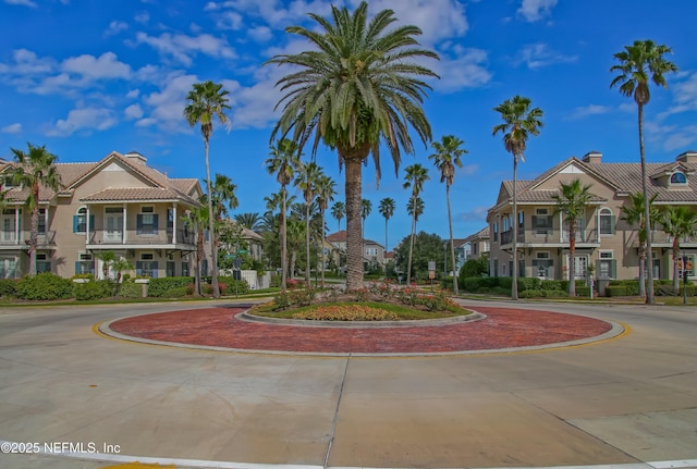 surrounding community featuring a residential view and curved driveway