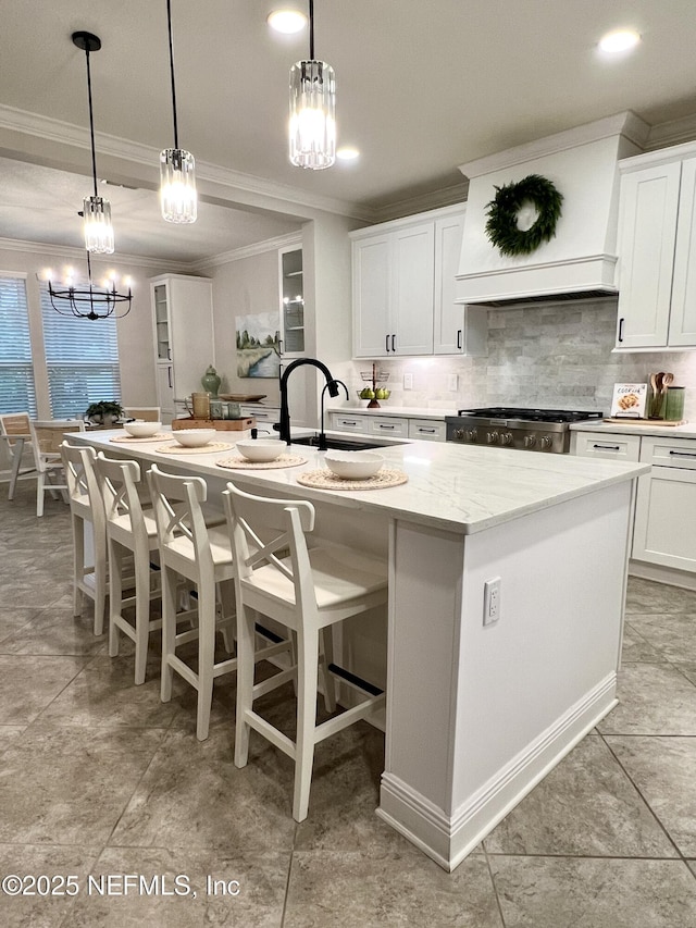 2714 Las Calinas Blvd, Saint Augustine, FL 32095 - kitchen featuring premium range hood, range, backsplash, an island with sink, and a notable chandelier