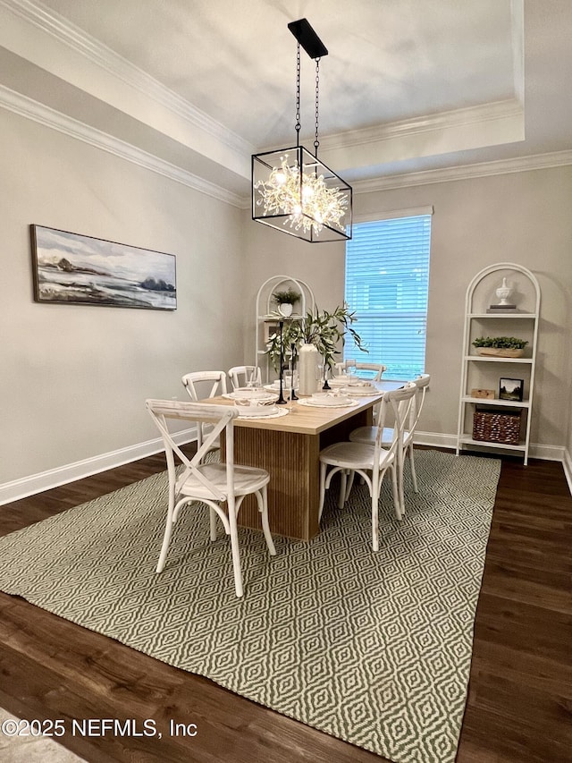 2714 Las Calinas Blvd, Saint Augustine, FL 32095 - dining area with a tray ceiling, a notable chandelier, dark wood finished floors, baseboards, and ornamental molding