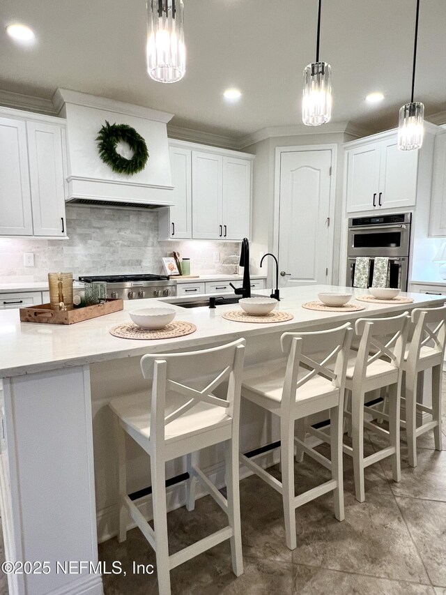 2714 Las Calinas Blvd, Saint Augustine, FL 32095 - kitchen featuring backsplash, white cabinets, stainless steel double oven, and a kitchen bar
