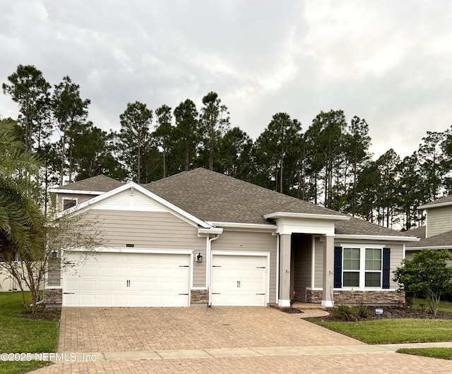 2714 Las Calinas Blvd, Saint Augustine, FL 32095 - view of front of home with decorative driveway, stone siding, a garage, and roof with shingles