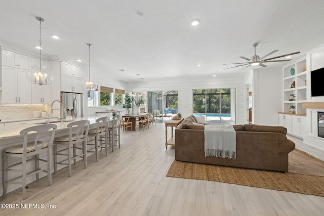 280 Quail Vista Dr, Ponte Vedra, FL 32081 - living room with ceiling fan, light wood-type flooring, a glass covered fireplace, and recessed lighting