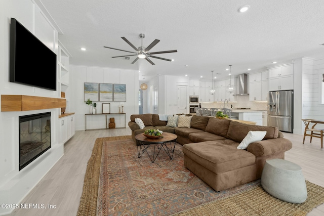 280 Quail Vista Dr, Ponte Vedra, FL 32081 - living area featuring ceiling fan, a textured ceiling, recessed lighting, light wood finished floors, and a glass covered fireplace