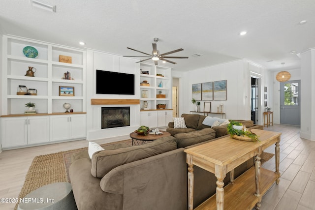 280 Quail Vista Dr, Ponte Vedra, FL 32081 - living room featuring a glass covered fireplace, light wood-type flooring, a textured ceiling, a ceiling fan, and visible vents