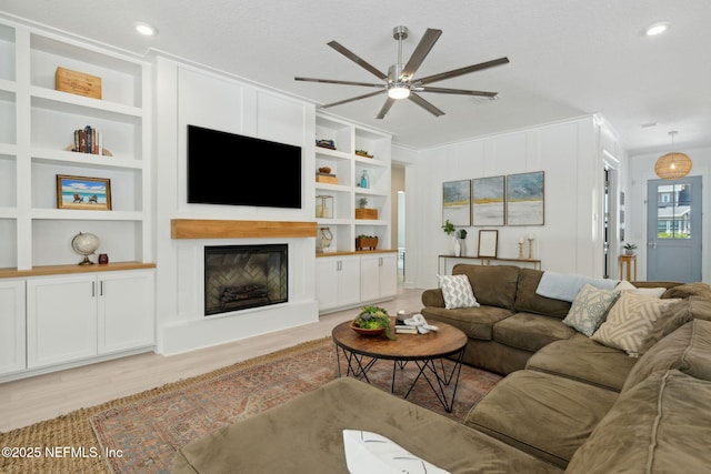 280 Quail Vista Dr, Ponte Vedra, FL 32081 - living room featuring light wood-style floors, ceiling fan, a glass covered fireplace, and built in shelves