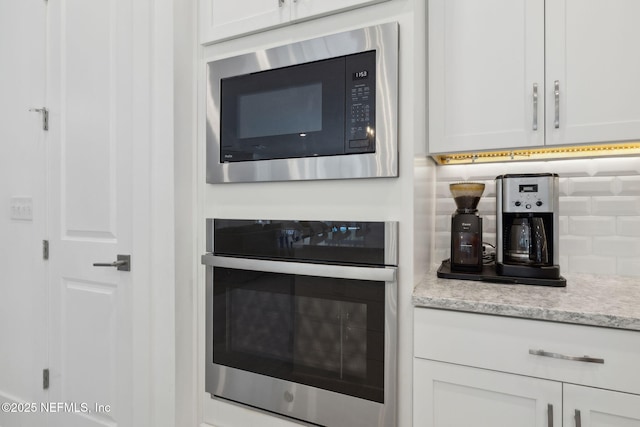 280 Quail Vista Dr, Ponte Vedra, FL 32081 - kitchen with white cabinetry, backsplash, appliances with stainless steel finishes, and light stone counters