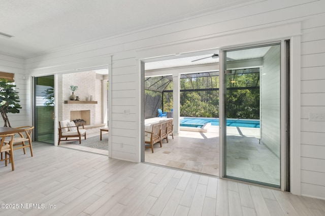 280 Quail Vista Dr, Ponte Vedra, FL 32081 - doorway featuring a sunroom, wood finished floors, wooden walls, and a large fireplace
