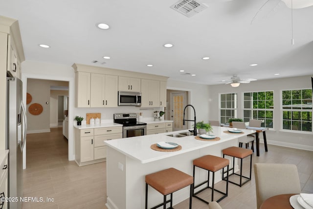 12847 Swamp Owl Ln, Jacksonville, FL 32258 - kitchen with stainless steel appliances, a sink, a breakfast bar, baseboards, and recessed lighting