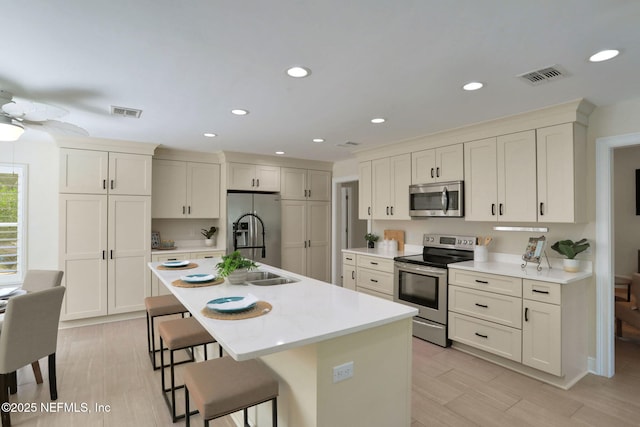 12847 Swamp Owl Ln, Jacksonville, FL 32258 - kitchen featuring appliances with stainless steel finishes, a breakfast bar, light countertops, a center island with sink, and recessed lighting