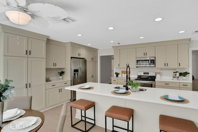 12847 Swamp Owl Ln, Jacksonville, FL 32258 - kitchen featuring appliances with stainless steel finishes, a breakfast bar, light countertops, recessed lighting, and a sink