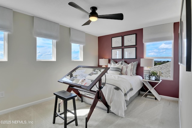bedroom with light colored carpet, baseboards, and a ceiling fan