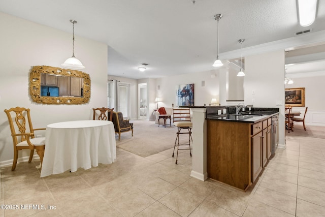 9831 Del Webb Pkwy Unit 3107, Jacksonville, FL 32256 - kitchen featuring a kitchen breakfast bar, light tile patterned flooring, dark countertops, visible vents, and a sink