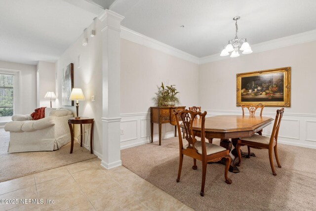 9831 Del Webb Pkwy Unit 3107, Jacksonville, FL 32256 - dining area featuring crown molding, a decorative wall, an inviting chandelier, light tile patterned floors, and light carpet