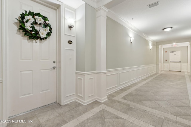 9831 Del Webb Pkwy Unit 3107, Jacksonville, FL 32256 - foyer entrance featuring ornamental molding, visible vents, wainscoting, decorative columns, and a decorative wall