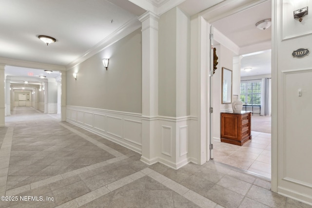 9831 Del Webb Pkwy Unit 3107, Jacksonville, FL 32256 - hallway featuring crown molding, a decorative wall, decorative columns, and wainscoting
