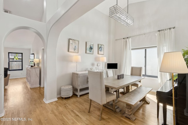 185 Crosscove Cir, Ponte Vedra Beach, FL 32082 - dining space featuring visible vents, baseboards, arched walkways, light wood finished floors, and a towering ceiling