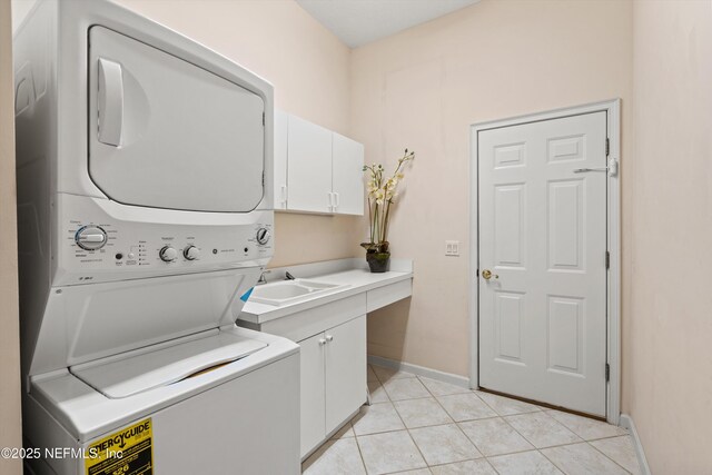 1952 Quaker Ridge Dr, Green Cove Springs, FL 32043 - laundry area featuring baseboards, light tile patterned floors, stacked washer / drying machine, cabinet space, and a sink