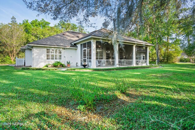 1952 Quaker Ridge Dr, Green Cove Springs, FL 32043 - rear view of house with a sunroom, roof with shingles, stucco siding, and a lawn