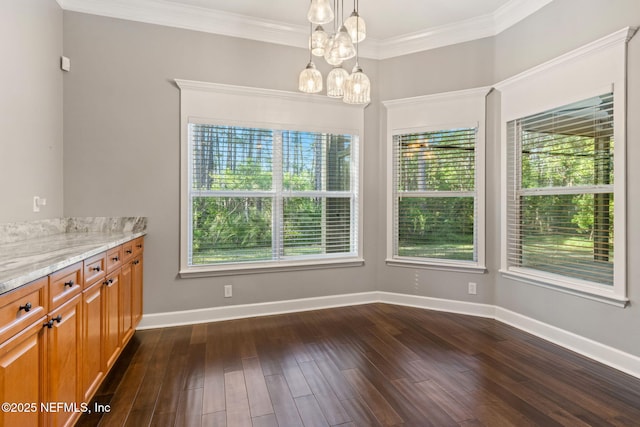 unfurnished dining area featuring an inviting chandelier, dark wood-type flooring, baseboards, and crown molding