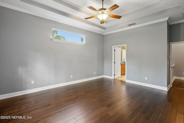 empty room with a ceiling fan, dark wood-style floors, a tray ceiling, and visible vents