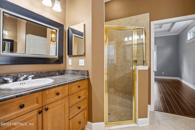 bathroom with a stall shower, baseboards, tile patterned flooring, and vanity