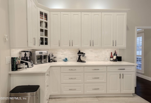 4394 Apple Tree Pl, Jacksonville, FL 32258 - kitchen with light wood finished floors, glass insert cabinets, tasteful backsplash, and white cabinets
