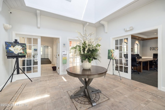 1825 Vista Cove Rd, Saint Augustine, FL 32084 - corridor featuring french doors, a towering ceiling, arched walkways, and baseboards