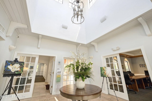 1825 Vista Cove Rd, Saint Augustine, FL 32084 - dining space with a high ceiling, a chandelier, light tile patterned floors, arched walkways, and french doors