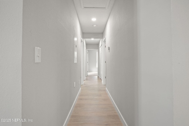 hall with baseboards and light wood-style floors