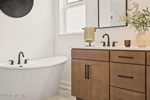 bathroom with a freestanding tub and vanity