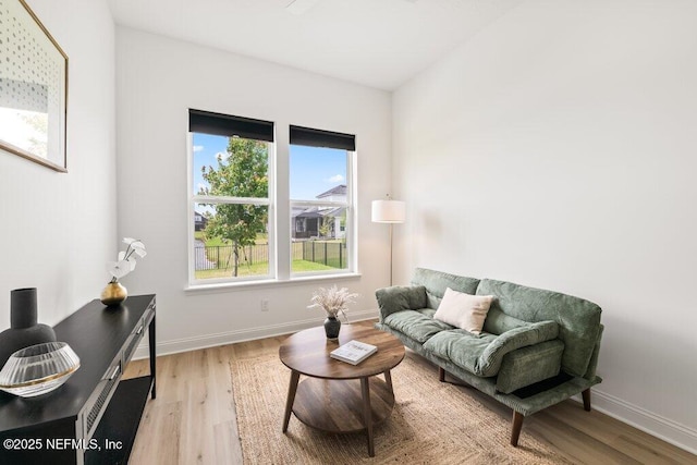 living room featuring baseboards, wood finished floors, and a wealth of natural light