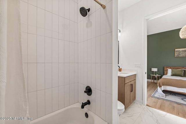 ensuite bathroom featuring shower / bath combination with curtain, marble finish floor, toilet, ensuite bathroom, and vanity