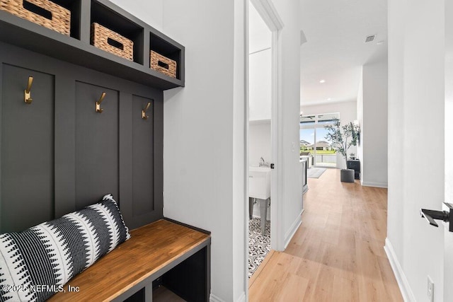 mudroom featuring light wood-type flooring, recessed lighting, and baseboards