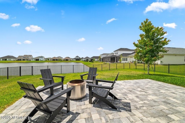 view of patio with a fire pit, a water view, a residential view, and a fenced backyard