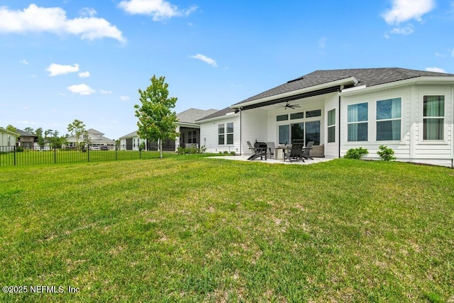 back of property with a lawn, a patio, ceiling fan, and fence