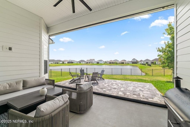 view of patio / terrace featuring a residential view, an outdoor living space, ceiling fan, a water view, and a fenced backyard