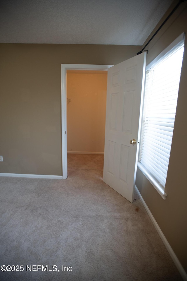 spare room with carpet and baseboards