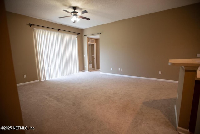 unfurnished living room with ceiling fan, carpet, baseboards, and a textured ceiling