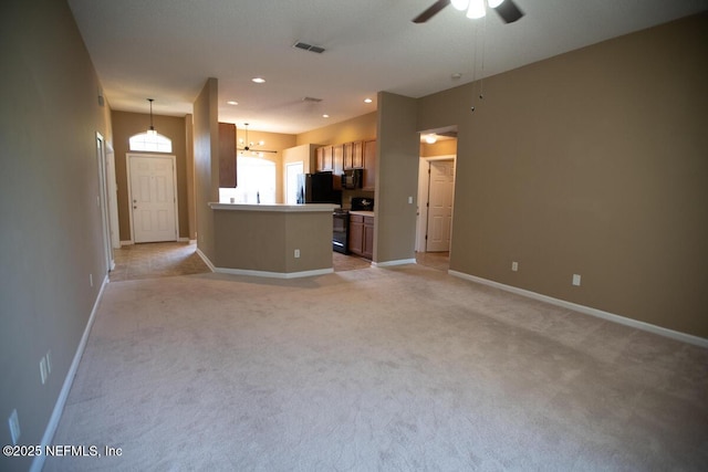 unfurnished living room with visible vents, baseboards, recessed lighting, ceiling fan with notable chandelier, and light colored carpet