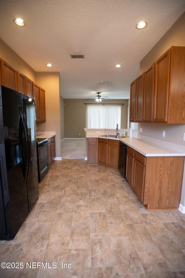 kitchen with visible vents, brown cabinetry, and black appliances