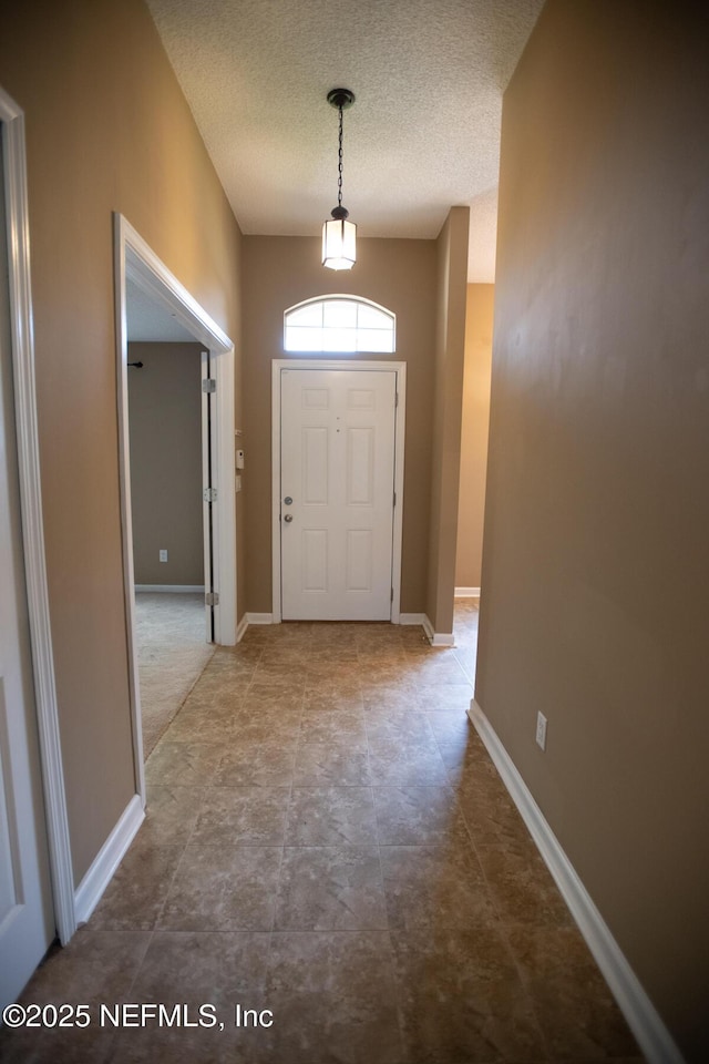 entryway featuring baseboards and a textured ceiling