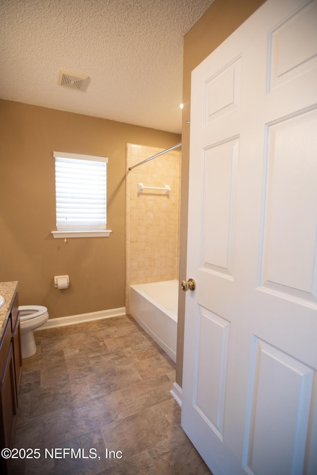 bathroom featuring vanity, baseboards, a textured ceiling, toilet, and visible vents