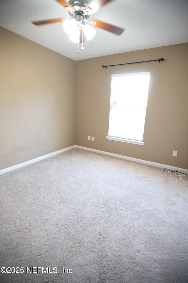 carpeted spare room with baseboards and ceiling fan