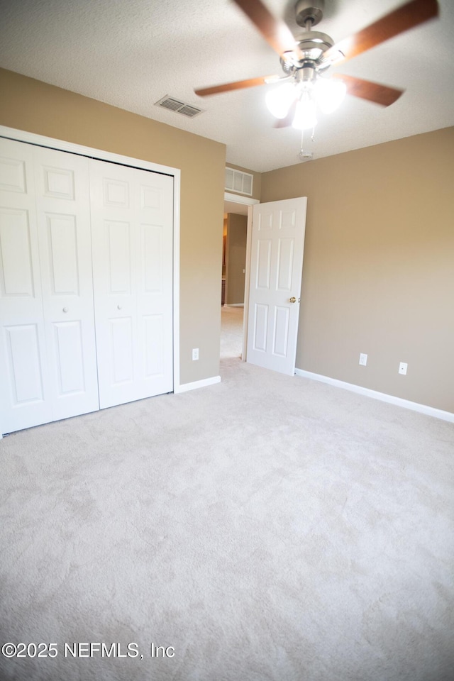 unfurnished bedroom featuring carpet flooring, a closet, baseboards, and ceiling fan