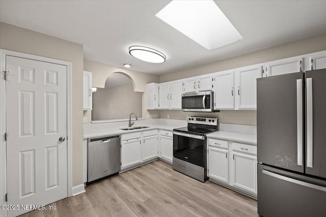 2931 Lantana Lakes Dr W, Jacksonville, FL 32246 - kitchen with white cabinetry, light countertops, stainless steel appliances, a sink, and light wood finished floors