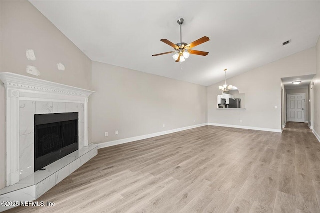 2931 Lantana Lakes Dr W, Jacksonville, FL 32246 - unfurnished living room featuring a tile fireplace, ceiling fan with notable chandelier, light wood-style floors, and baseboards