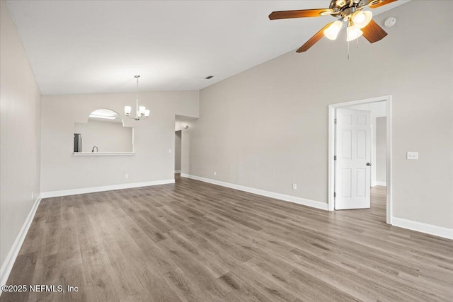 2931 Lantana Lakes Dr W, Jacksonville, FL 32246 - unfurnished living room featuring ceiling fan with notable chandelier, lofted ceiling, wood finished floors, and baseboards